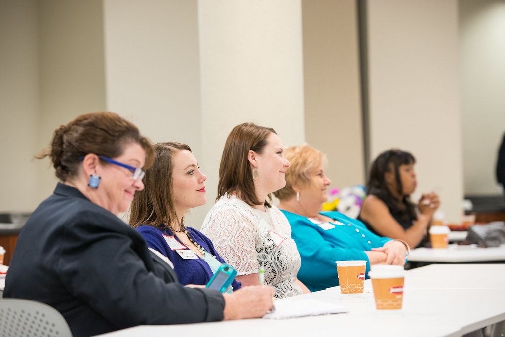 A workshop presenter speaking with a seated audience