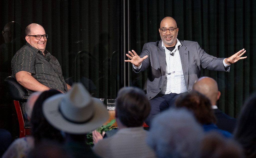 Two authors in conversation on stage before an audience