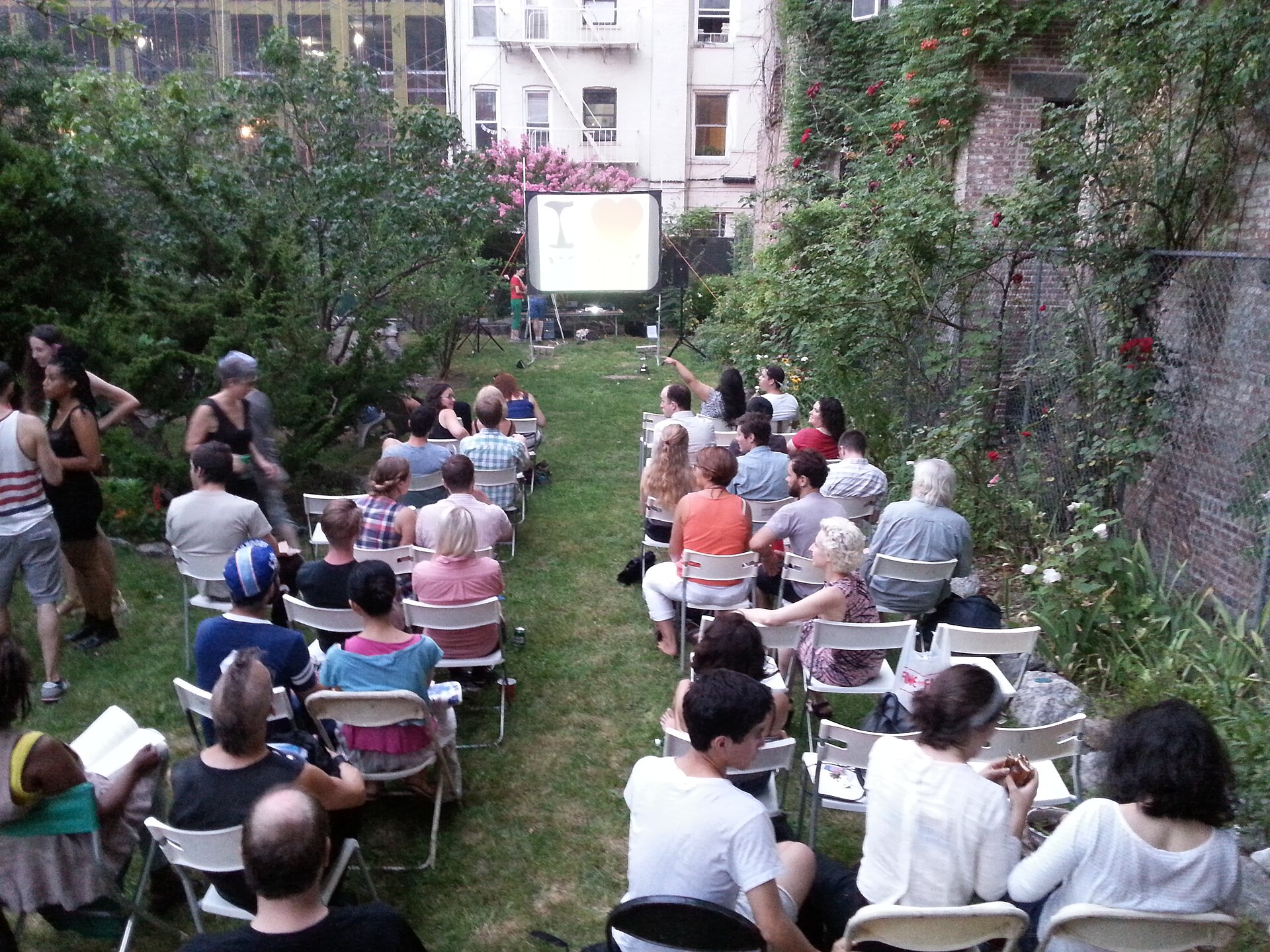 An audience watching an outdoor film screening at night
