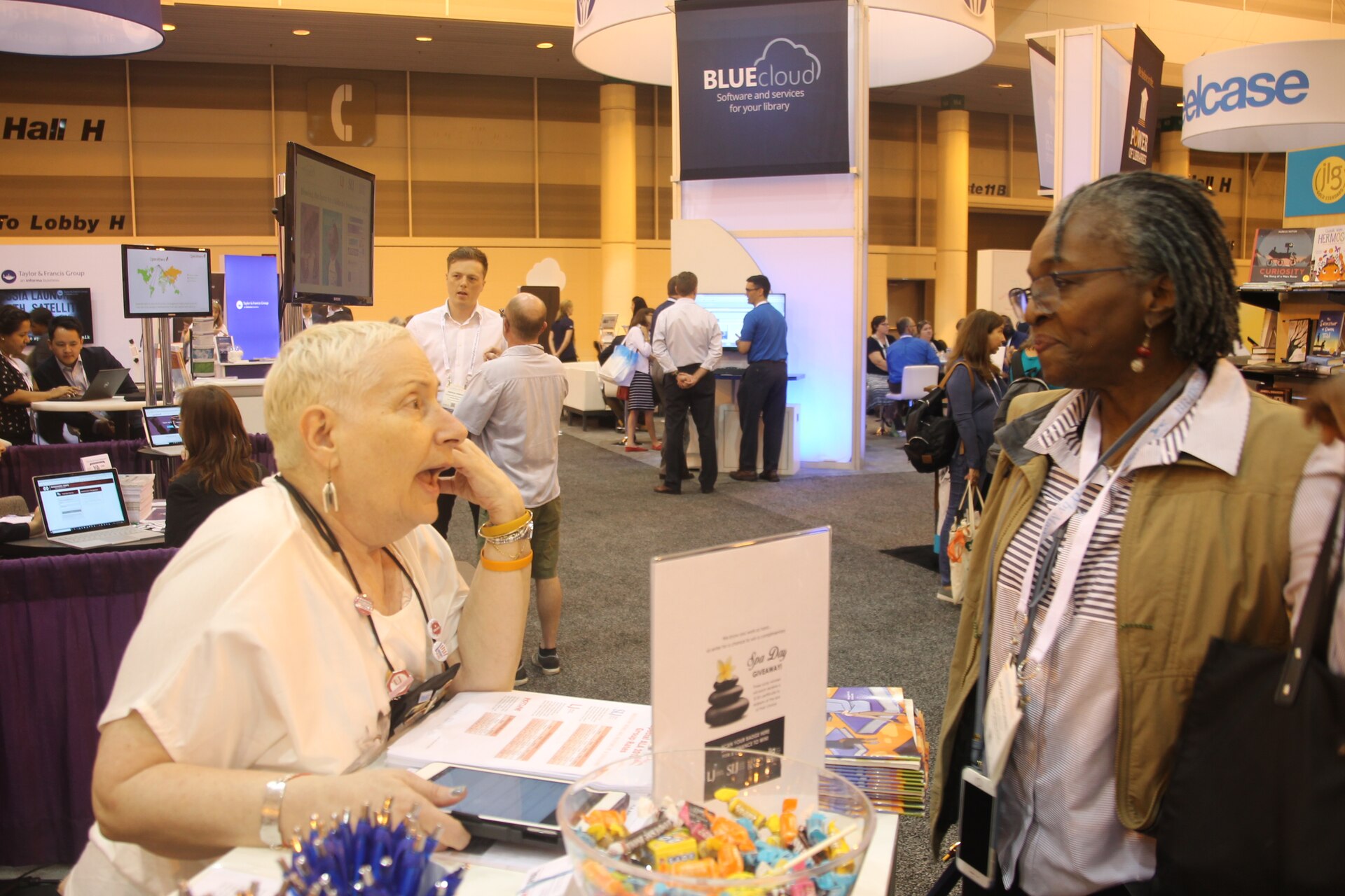 People talking at an American Library Association conference booth
